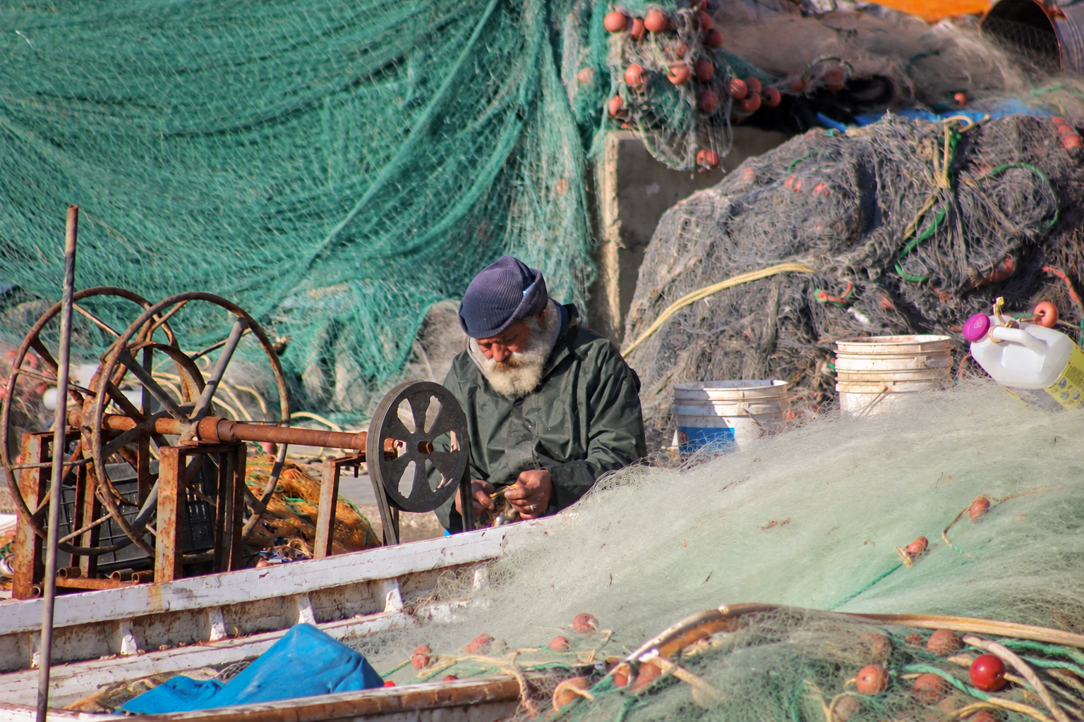 Un pêcheur au travail entre filets et treuils