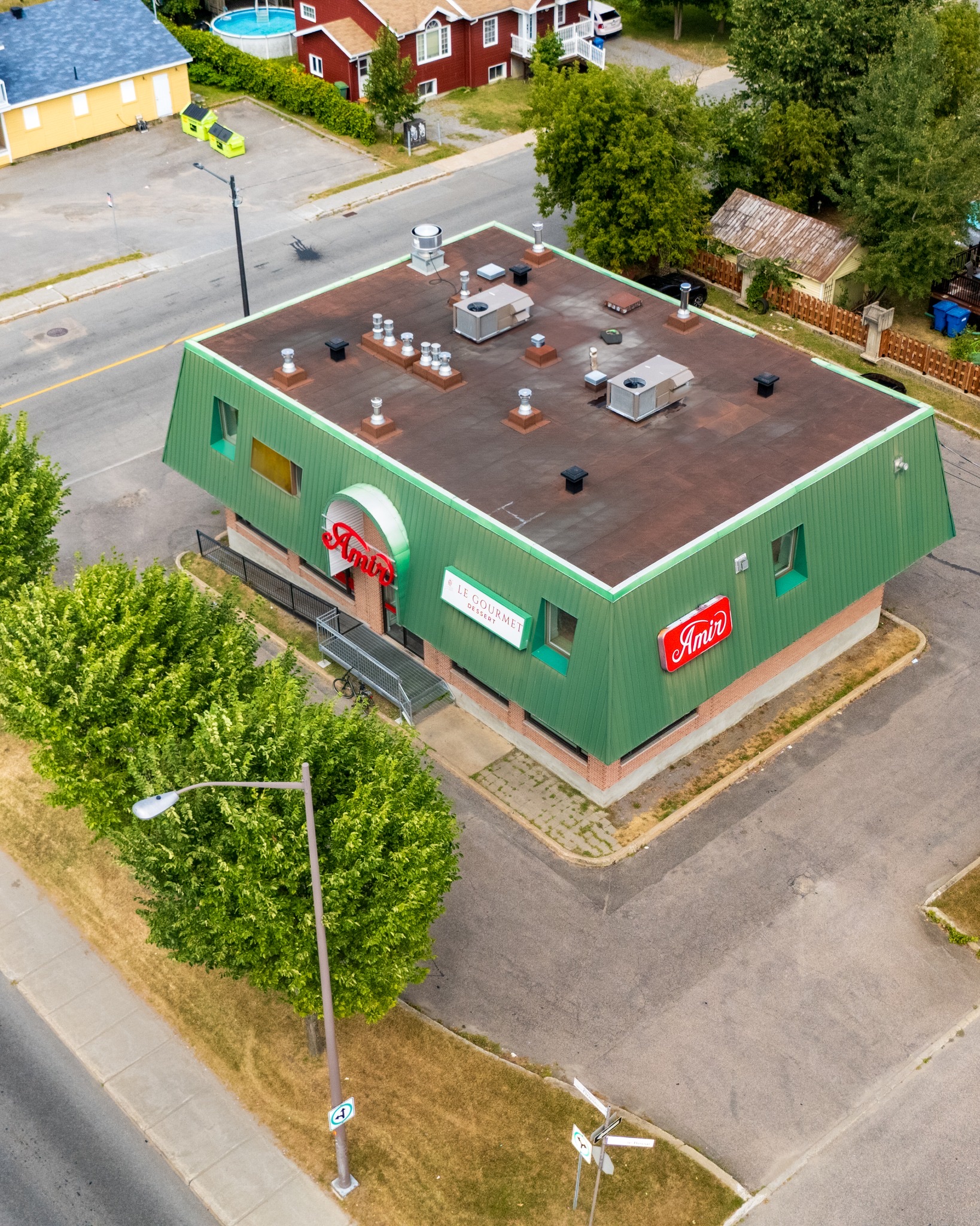 Aerial view of a commercial building with a green roof.